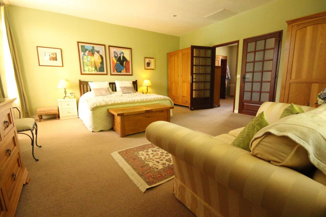 Surrounded by over 8 acres of glorious land with beautiful gardens, pond an