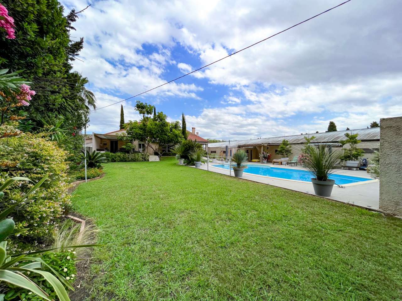 Nestling in 13.5 acres of beautiful landscaped gardens with expansive pool,