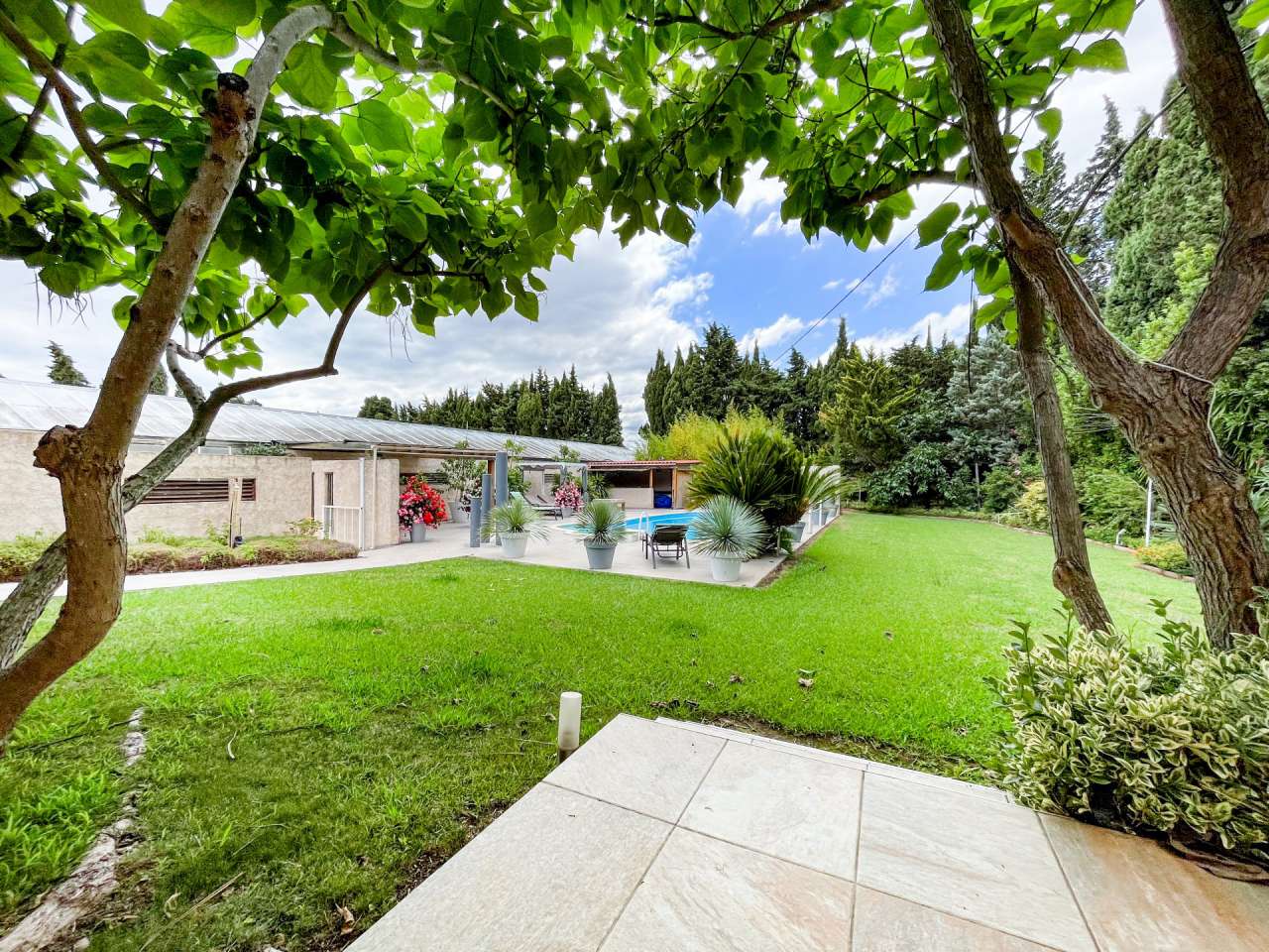 Nestling in 13.5 acres of beautiful landscaped gardens with expansive pool,