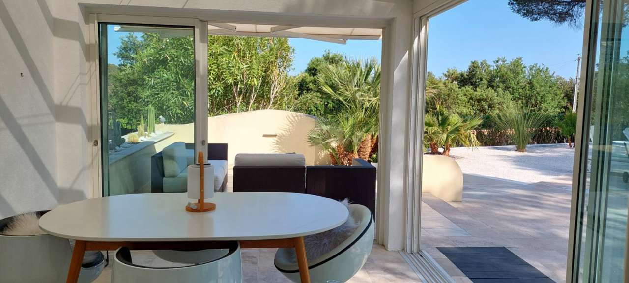 Nestling in beautiful landscaped gardens with pool, is this stylishly renov